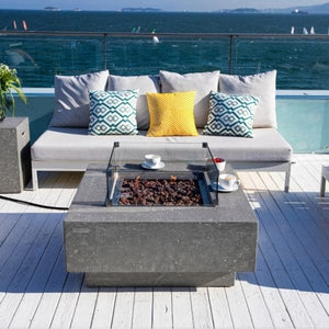Elementi Manhattan fire pit table on a patio deck with a windguard