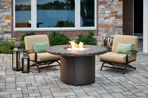 The outdoor greatroom company brown Beacon fire table shown on a patio with a flame