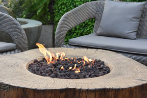 Elementi manchester fire pit tree stump shown with flame on a patio