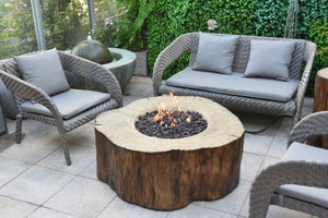 Elementi manchester fire pit tree stump shown with flame on a patio