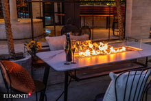 Load image into Gallery viewer, Elementi Plus Oslo outdoor dining table  with flame in an evening setting