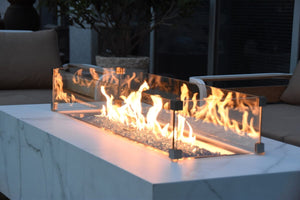 elementi plus carrara fire table with flame and wind guard on a patio