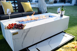 elementi plus carrara fire table with flame and lid shown in a patio setting