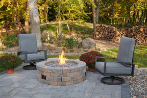 Bronson fire pit kit with a flame on a patio with outdoor greatroom swivel chairs